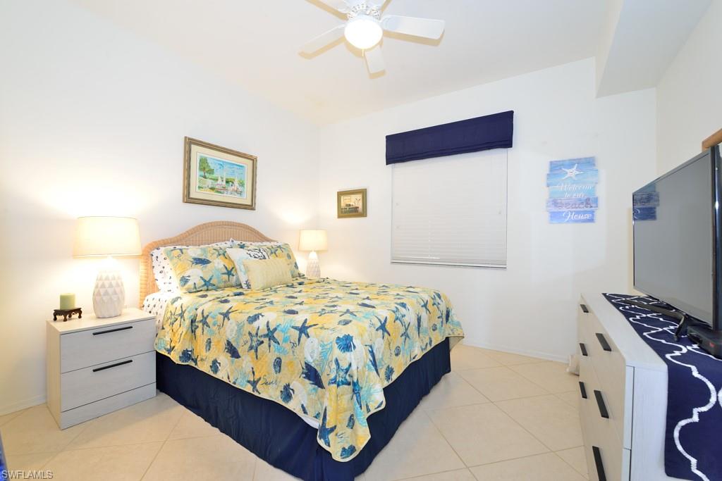 3830 Sawgrass Way, Unit 2934 Naples, FL 34112 - Photo 10 of 16 a bedroom with a bed and a chandelier