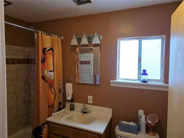 a bathroom with a sink a mirror and a window