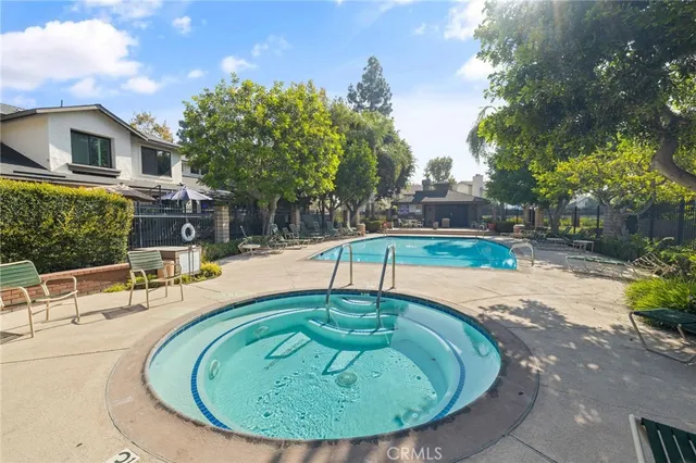 a swimming pool with outdoor seating and plants