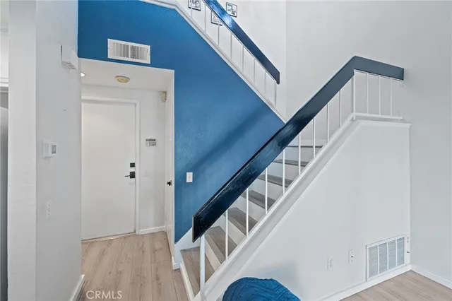 a view of staircase with railing and white walls