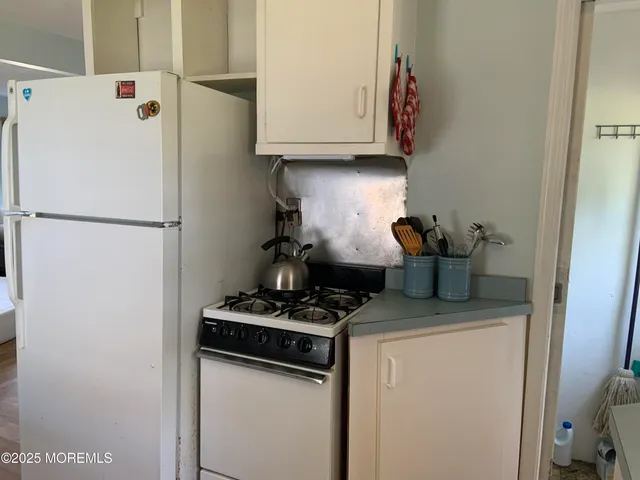 a kitchen with a refrigerator and a stove