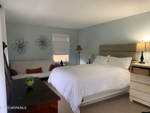 a bedroom with a bed and painting on the wall