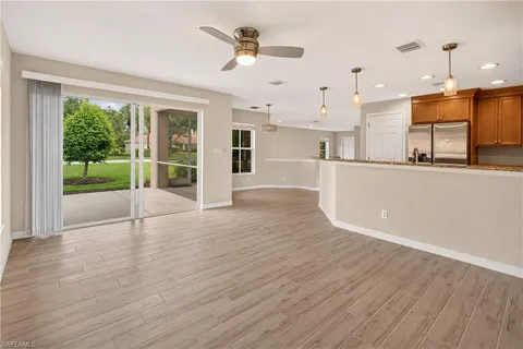 a view of empty room with wooden floor and window