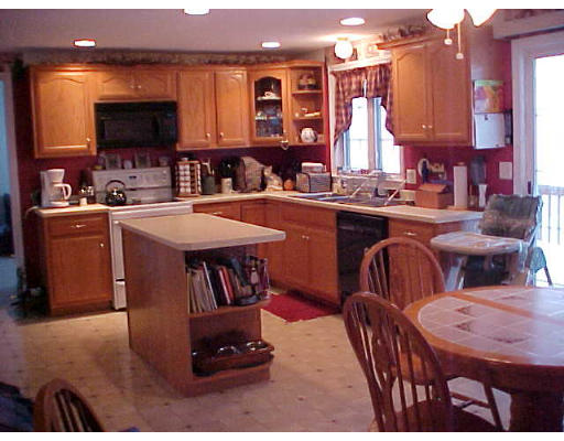 44 Fairview Park Road Sturbridge, MA 01566 - Photo 5 of 7 a kitchen with stainless steel appliances granite countertop a stove a sink dishwasher a dining table and chairs with wooden floor