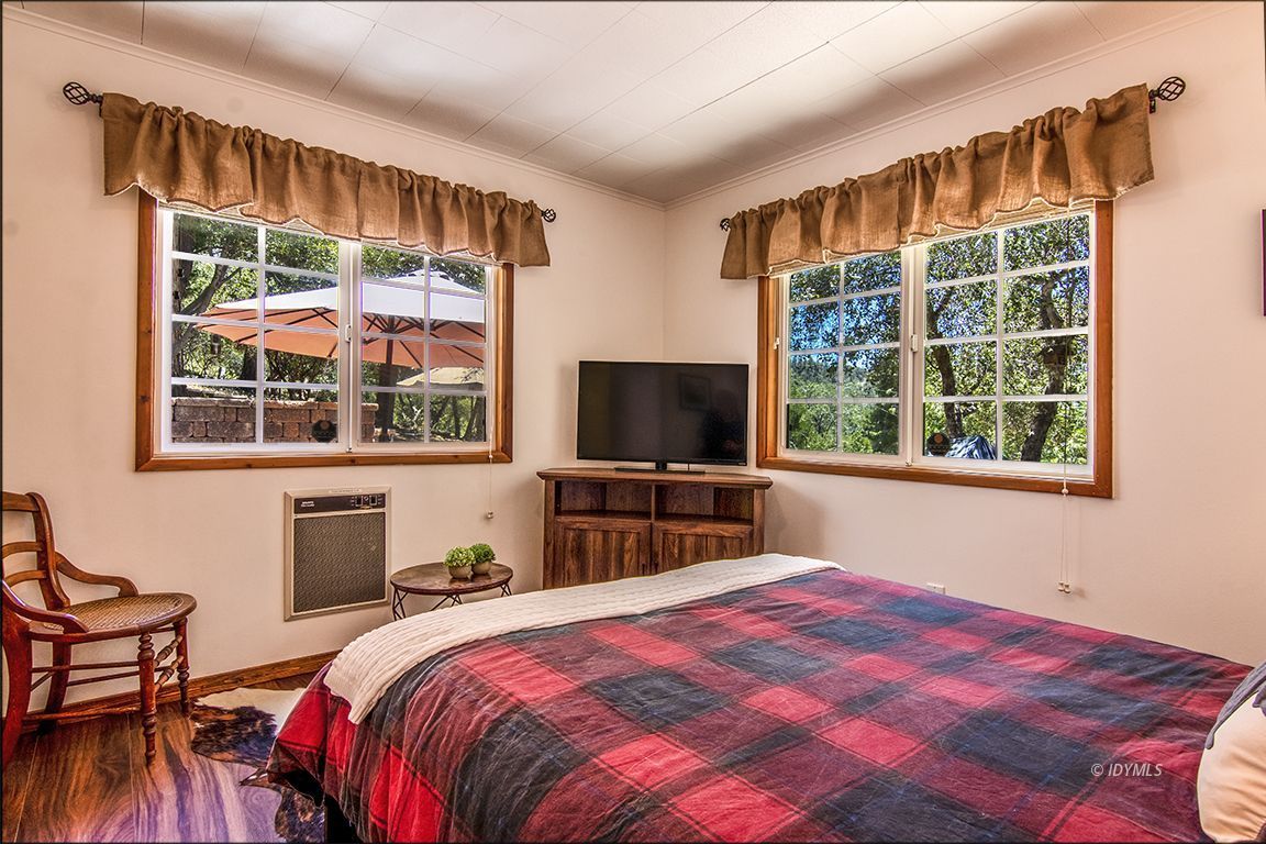 54440 Valley-View Idyllwild, CA 92549 - Photo 25 of 53 a bedroom with a bed and a flat tv screen next to a window