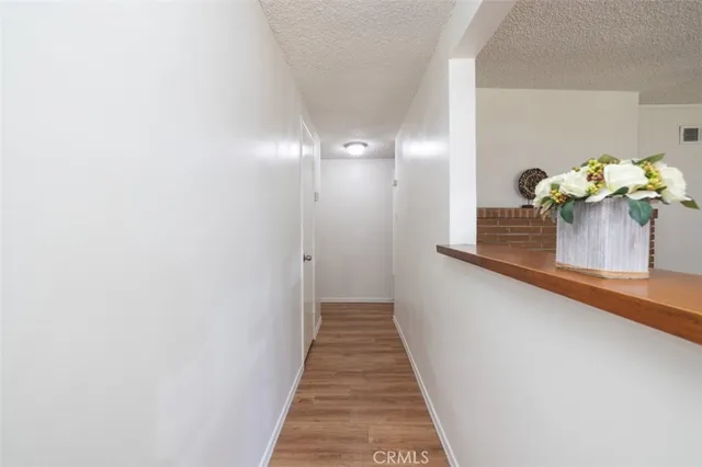 an empty room with wooden floor chandelier fan and windows