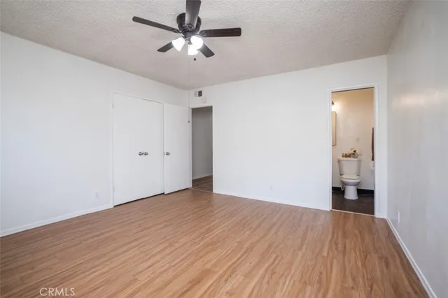 a view of a room with a ceiling fan and wooden floor