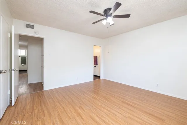 an empty room with a ceiling fan and window