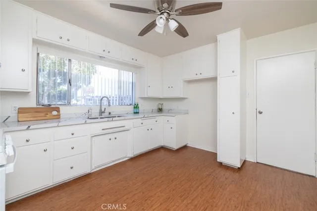 a kitchen with granite countertop white cabinets and white appliances