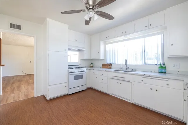 a kitchen with granite countertop white cabinets and white appliances