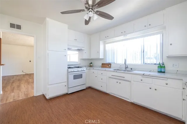 a kitchen with white cabinets and white appliances