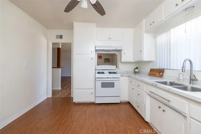 a kitchen with a sink cabinets and wooden floor