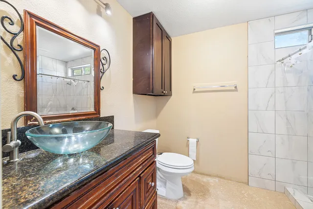 a bathroom with a granite countertop sink and a mirror