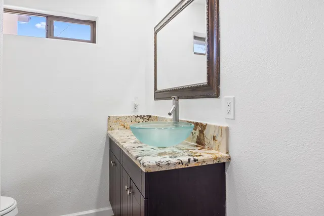 a utility room with a sink and a mirror
