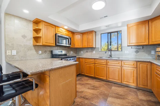 a kitchen with stainless steel appliances granite countertop a sink stove and window