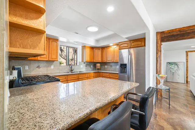 a kitchen with stainless steel appliances granite countertop a sink refrigerator and cabinets