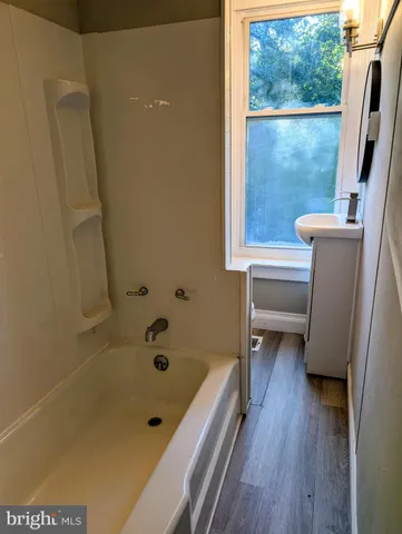 a bathroom with a bathtub and a window