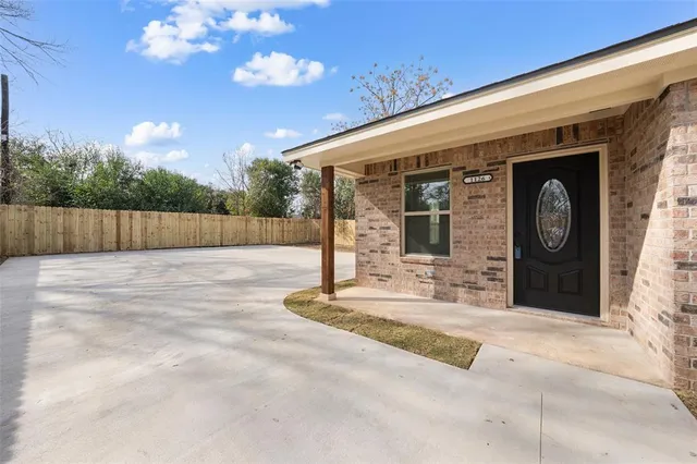 a view of a house with backyard and tree