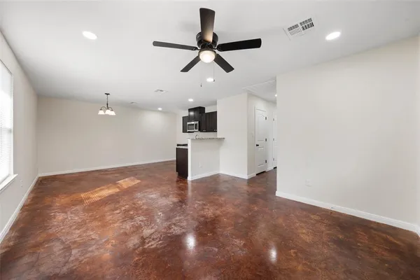 a view of an empty room and kitchen view