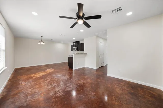 a view of an empty room and kitchen view