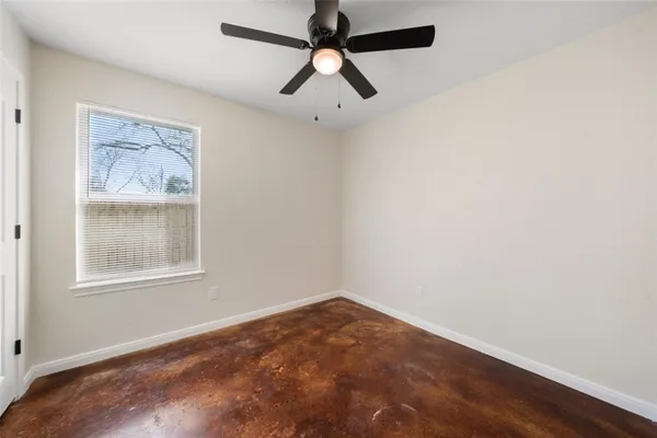 an empty room with a window and a fan