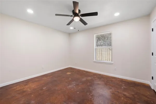 an empty room with a window and a fan