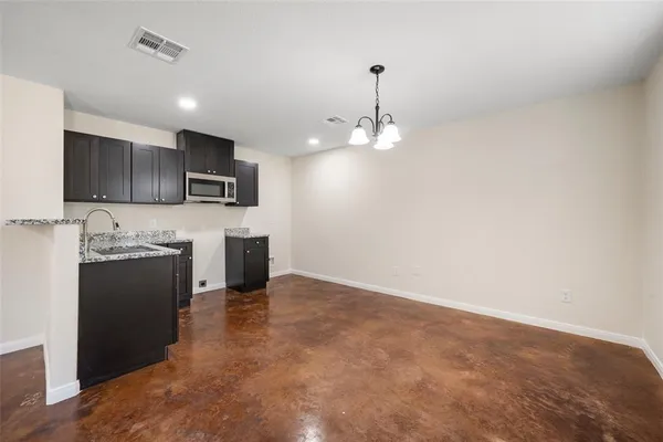 a view of a kitchen with a sink and dishwasher a refrigerator with wooden floor