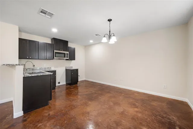 a view of a kitchen with a sink and dishwasher a refrigerator with wooden floor