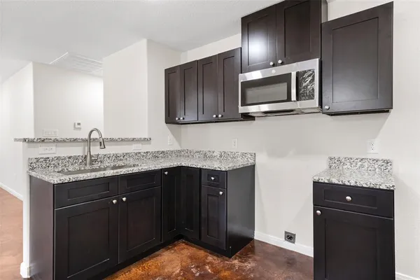 a kitchen with granite countertop stainless steel appliances and wooden cabinets