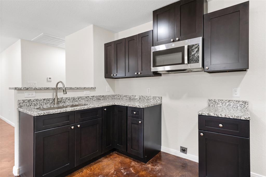 1126 North 11th Street Waco, TX 76707 - Photo 5 of 22 a kitchen with granite countertop stainless steel appliances and wooden cabinets