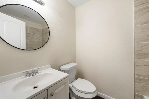 a bathroom with a sink mirror and toilet