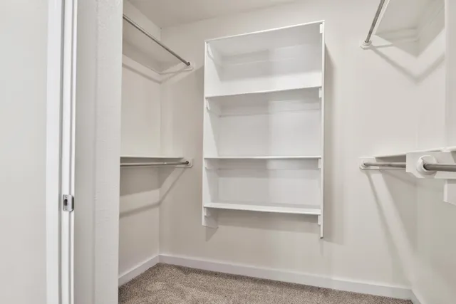 a view of walk in closet with empty racks