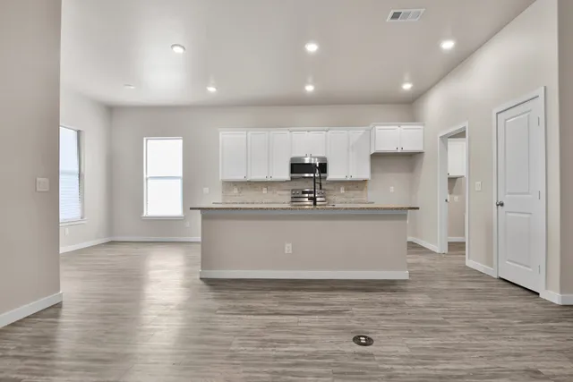 a view with kitchen island a sink wooden floor and a refrigerator