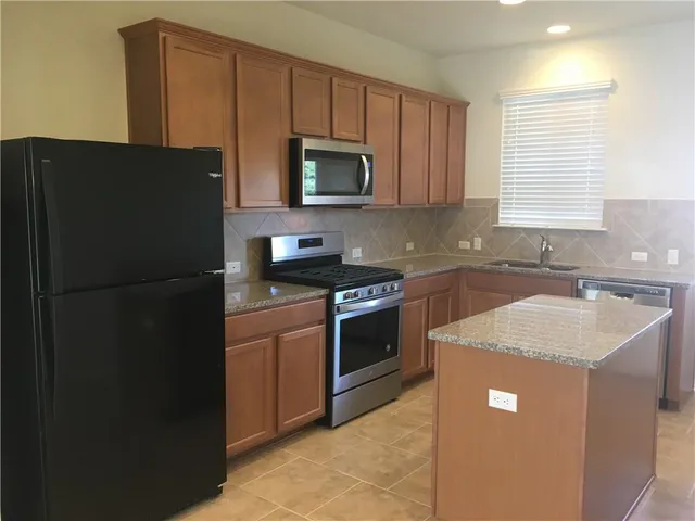 a kitchen with a sink stove and refrigerator