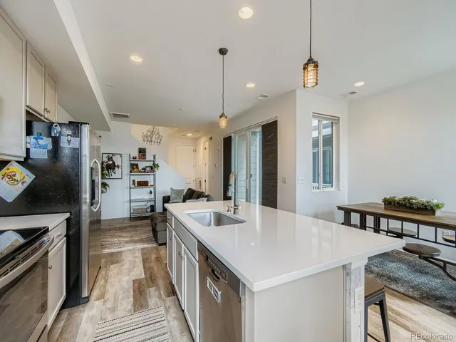 a kitchen with stainless steel appliances granite countertop a sink a stove and a refrigerator