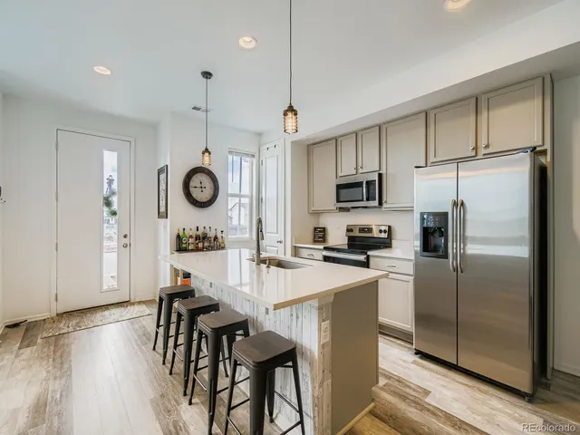 a kitchen with kitchen island a refrigerator stove microwave and cabinets