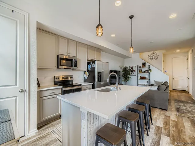 a kitchen with kitchen island a stove a table and chairs in it