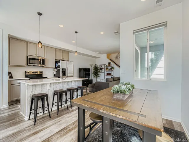 a kitchen with kitchen island granite countertop a table chairs a sink and cabinets