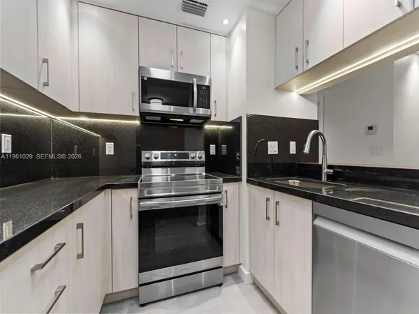 a kitchen with stainless steel appliances granite countertop a sink and a stove