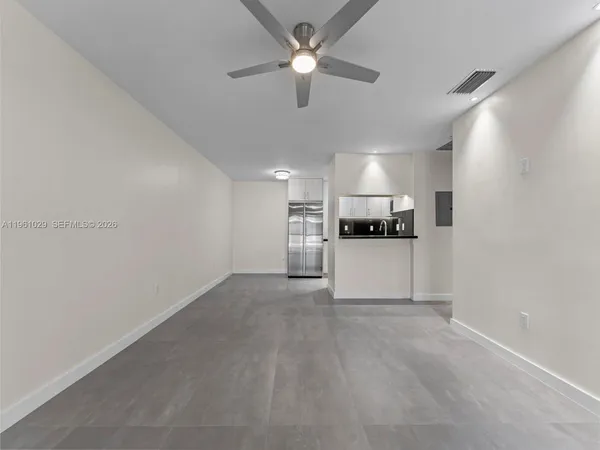 a view of a kitchen with a sink and a refrigerator