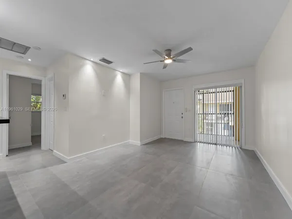 an empty room with fan and windows