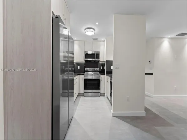 a view of a kitchen with a sink and dishwasher a refrigerator with wooden floor
