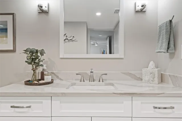 a bathroom with a granite countertop sink toilet a mirror and shower