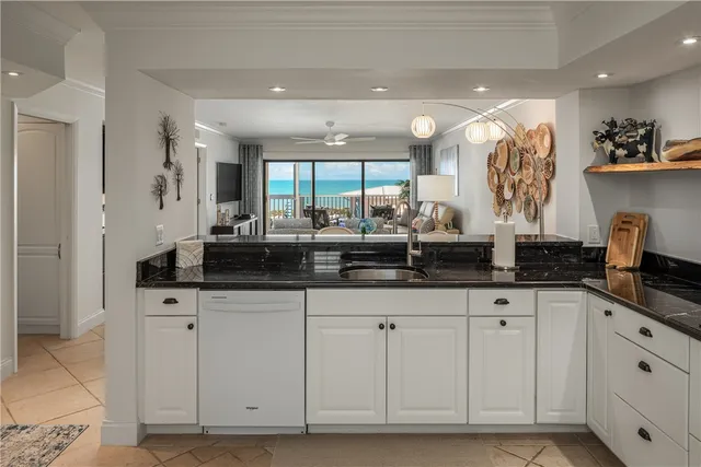 a kitchen with granite countertop white cabinets and black appliances