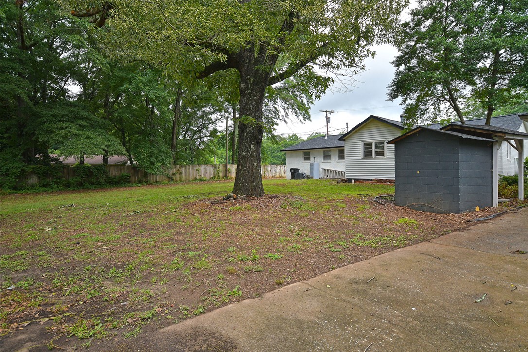 115 Stancil Road Anderson, SC 29625 - Photo 3 of 35 A spacious backyard with mature trees and a dedicated shed, offering ample outdoor living potential.