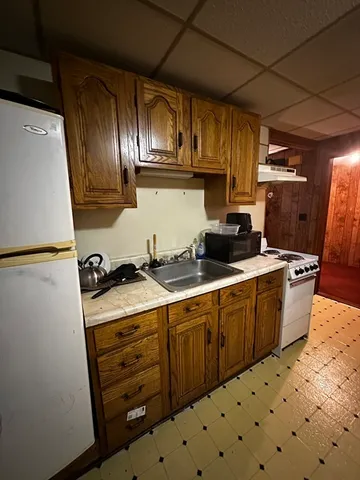 a kitchen with granite countertop a sink a stove and wooden cabinets