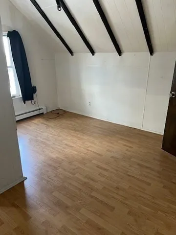a view of a room with wooden floor and cabinet
