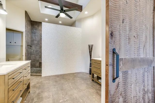 a bathroom with a granite countertop sink a toilet and shower