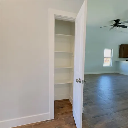 a view of a room with wooden floor and a window