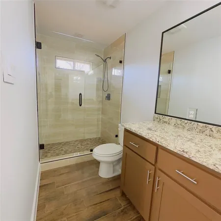 a bathroom with a granite countertop sink toilet and shower